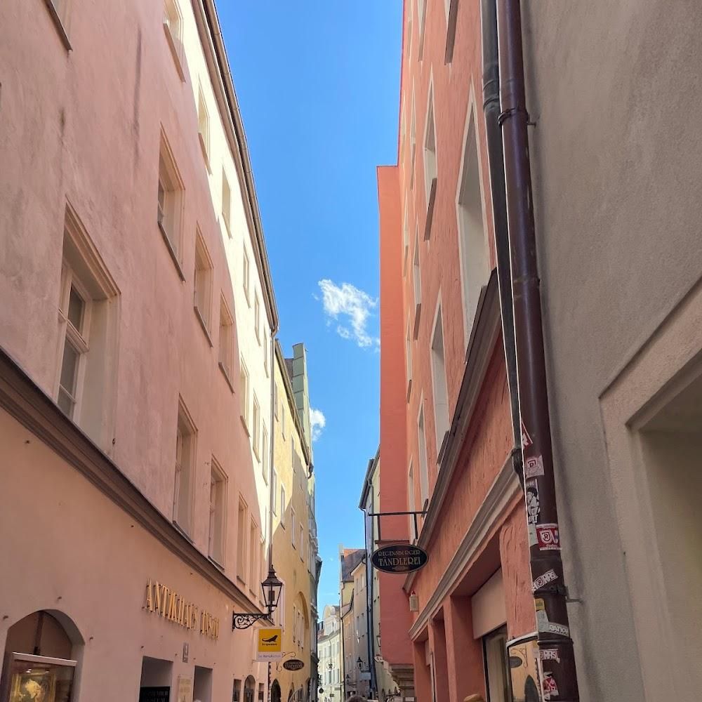 A narrow, cobblestone alleyway lined with colorful buildings.